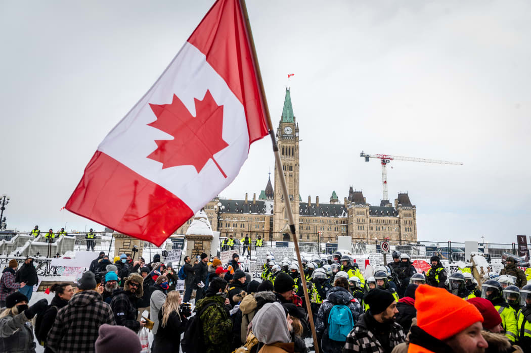 Demonstrators continue their protest in front of Parliament Hill in Ottawa as police deploy to remove them.