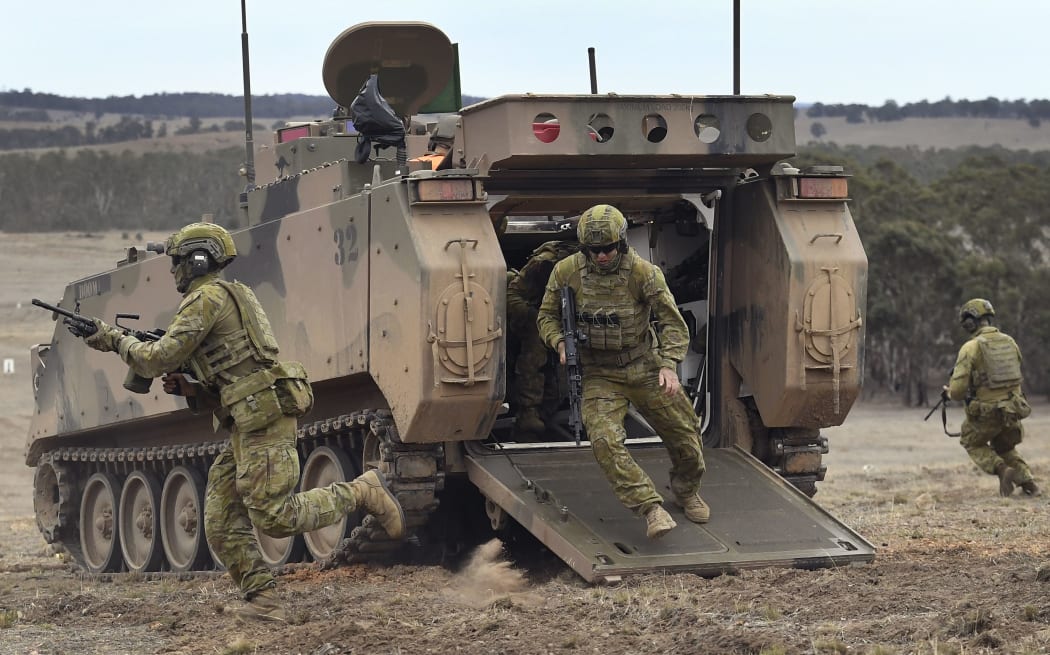 Australian Army soldiers run from an armoured personnel carrier during Excercise Chong Ju, a live fire demonstration showcasing the army's joint combined arms capabilities at the Puckapunyal Military Base north of Melbourne on May 9, 2019.