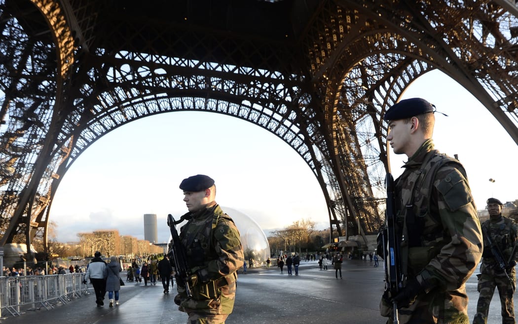 French soldiers patrol in front of the Eiffel Tower.