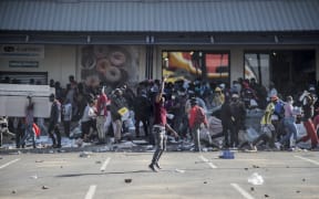 A man gestures as rioters loot the Jabulani Mall in the Soweto district of Johannesburg on July 12, 2021.