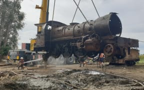 The V class locomotive is hoisted from the river at last.