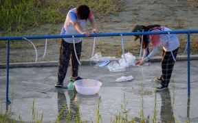 Scouts fill up containers of water at the campsite of the World Scout Jamboree in Buan, North Jeolla province on 5 August, 2023.