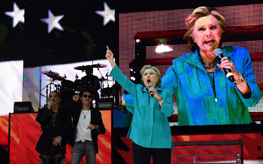 US Democratic presidential nominee Hillary Clinton speaks as singer Jennifer Lopez and Marc Anthony look on during “Go Out to Vote” concert at the Bayfront Park Amphitheater in Miami.
