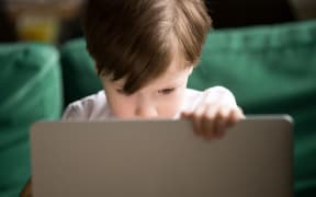 Curious interested kid boy secretly looking watching forbidden censored adult only internet online video content on laptop alone, parental protection, computer control and security for child concept