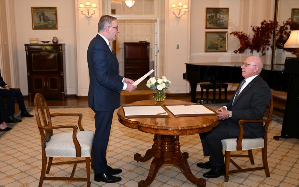 Australia's new Prime Minister Anthony Albanese (L) takes an oath in front of Australia's Governor General David Hurley (R) at Government House in Canberra on May 23, 2022. (Photo by SAEED KHAN / AFP)