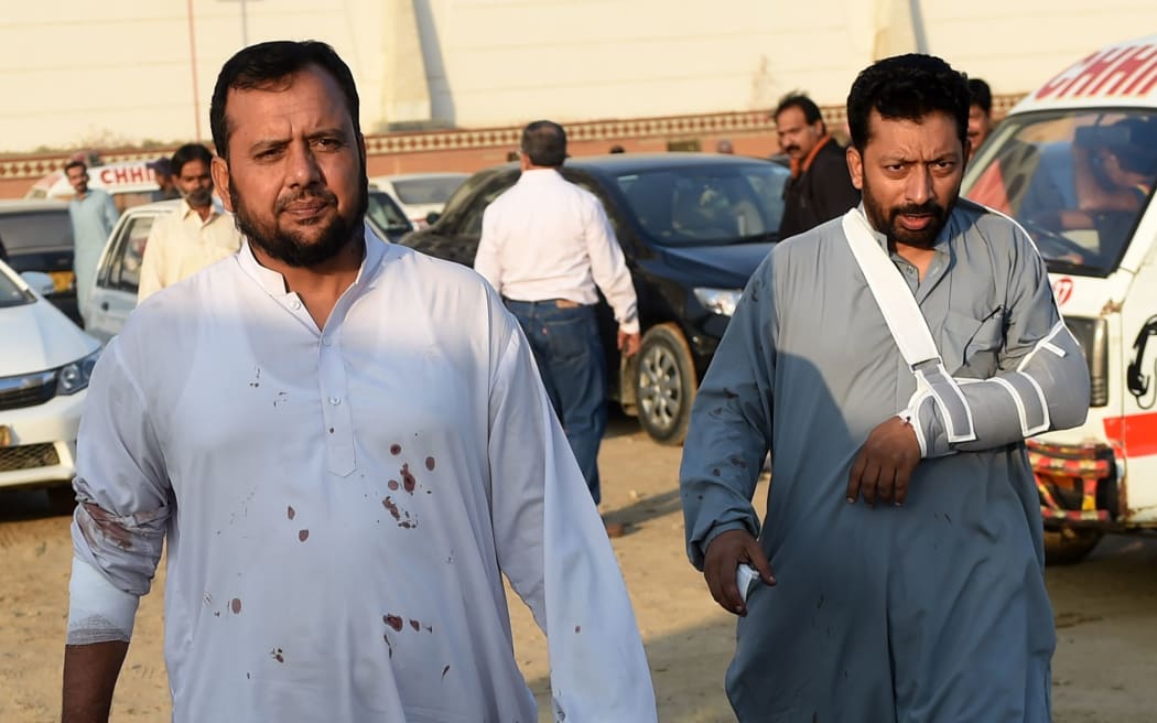 Injured guests walk around outside the hotel.