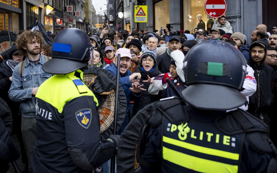 AMSTERDAM - Police officers drive people away from Dam Square during a Pro-Palestinian protest. The protest is taking place while an emergency ordinance and demonstration ban are in place in the city. These were previously deployed following tensions and violence surrounding supporters of Israeli soccer club Maccabi Tel Aviv. ANP ROBIN VAN LONKHUIJSEN netherlands out - belgium out (Photo by ROBIN VAN LONKHUIJSEN / ANP MAG / ANP via AFP)