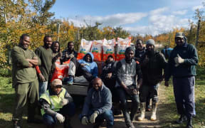 Workers from Vanuatu at Central Organics with produce donated to them after Cyclone Harold