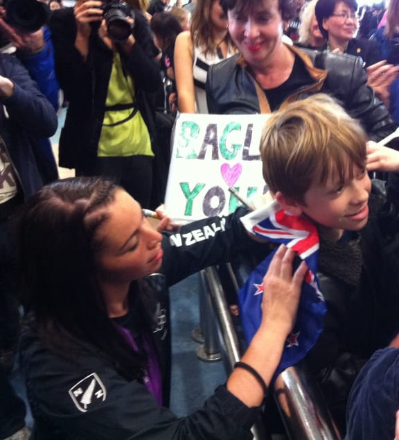 Sarah Walker signs a flag for a young supporter.