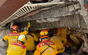 This handout from Taiwan's National Fire Agency taken and released on April 3, 2024 shows members of a rescue team searching for survivors in a damaged building in Hualien, after a major earthquake hit Taiwan's east. At least seven people were killed and more than 700 injured on April 3 by a powerful earthquake in Taiwan that damaged dozens of buildings and prompted tsunami warnings that extended to Japan and the Philippines before being lifted. (Photo by Handout / TAIWAN'S NATIONAL FIRE AGENCY / AFP) / RESTRICTED TO EDITORIAL USE - MANDATORY CREDIT "AFP PHOTO / TAIWAN'S NATIONAL FIRE AGENCY - NO MARKETING NO ADVERTISING CAMPAIGNS - DISTRIBUTED AS A SERVICE TO CLIENTS