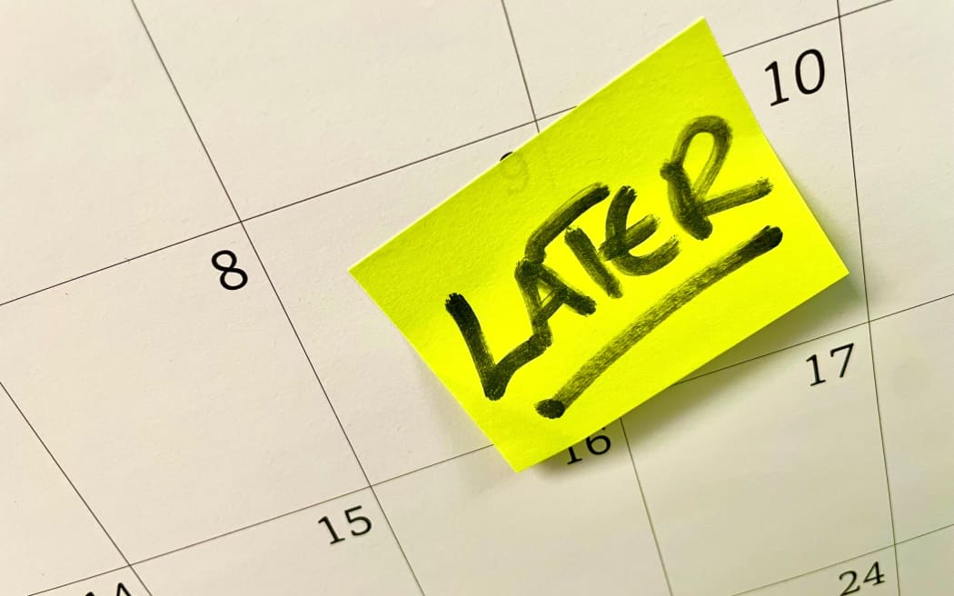 the word later written on a post-it note on a calendar.