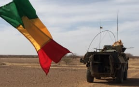 Soldiers of the France's Barkhane mission patrol in a military vehicle next to a Malian national flag on November 2, 2017 in central Mali, in the border zone with Burkina Faso and Niger as a joint anti-jihadist force linking countries in the Sahel began operations on November 1. The world's newest joint international force, the five-nation G5 Sahel plans to number up to 5,000 military, police and civilian troops by March 2018. The 5,000 will comprise two battalions each from Mali and Niger and one each from Burkina Faso, Chad and Mauritania. (Photo by Daphné BENOIT / AFP)
