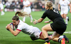 England's Leanne Infante scores a try despite Kendra Cocksedge of New Zealand.