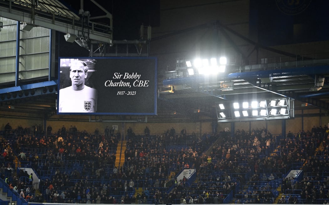 A photograph of legendary England midfielder Bobby Charlton is displayed on a big screen in the half-time break as news of his passing spreads, during the English Premier League football match between Chelsea and Arsenal at Stamford Bridge in London on October 21, 2023. England World Cup winner and Manchester United great Bobby Charlton, described by the club as a "giant of the game", has died at the age of 86, it was announced on Saturday. (Photo by JUSTIN TALLIS / AFP)