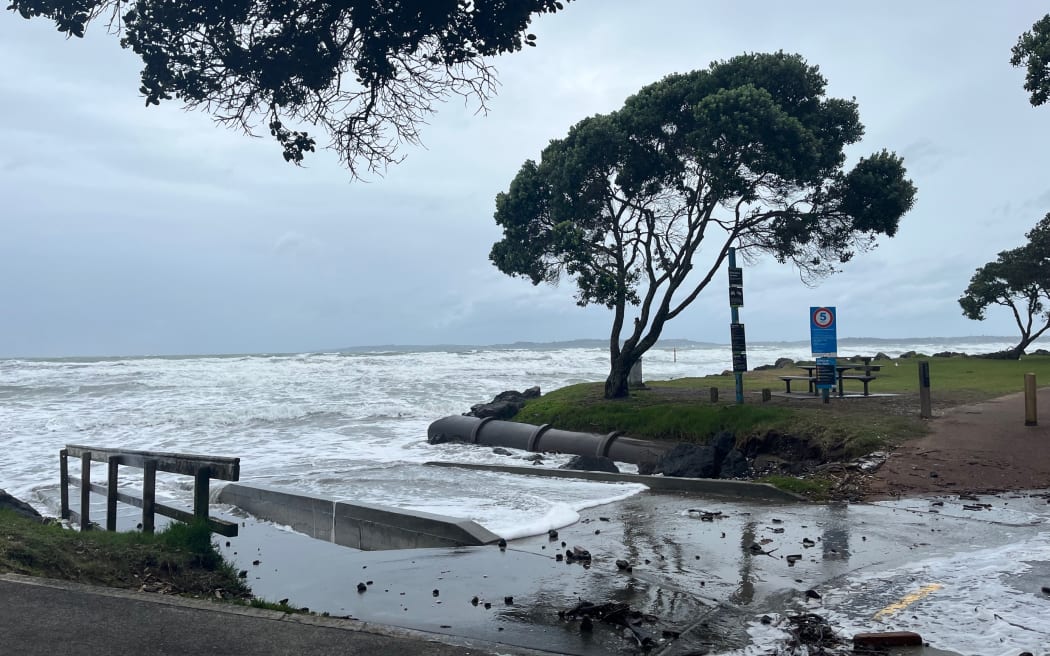 Strong winds and a high tide have washed away part of Orewa Beach in north Auckland. One kite surfer is out in the heavy swell.