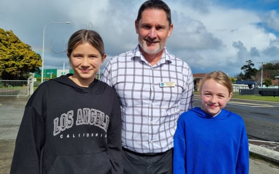 Azaria, left, and Amelia, with Spotswood Primary School principal Mark Fisher.