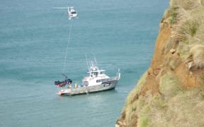 The helicopter successfully moves the wreck onto the charter boat.