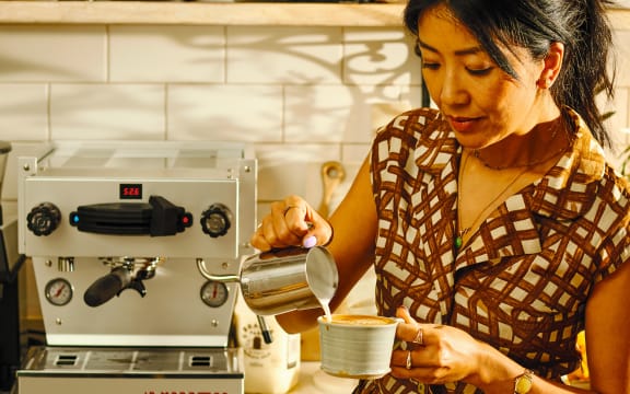 An image from Celeste Wong's book, Coffee Creations: 90 delicious recipes for the perfect cup. Celeste Wong pours milk into her coffee cup to make a flat white.