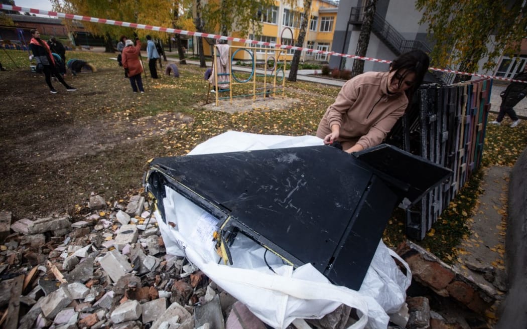 A preschool worker holds a wing from a Russian drone that crashed into a children's playground in Sumy, Ukraine.