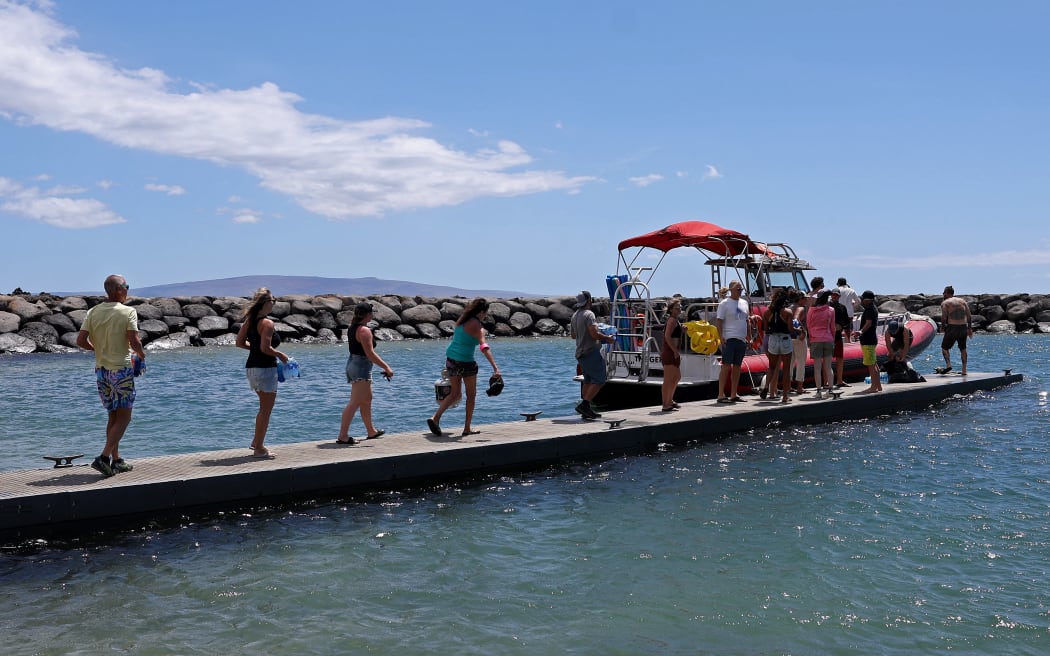 Volunteers load water onto a boat to be transported to West Maui from the Kihei boat landing.