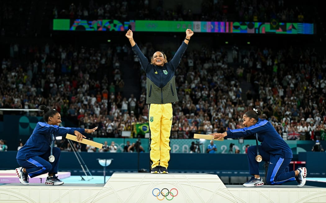 (LtoR) US' Simone Biles (silver), Brazil's Rebeca Andrade (gold) and US' Jordan Chiles (bronze) pose during the podium ceremony for the artistic gymnastics women's floor exercise event of the Paris 2024 Olympic Games at the Bercy Arena in Paris, on August 5, 2024. (Photo by Gabriel BOUYS / AFP)