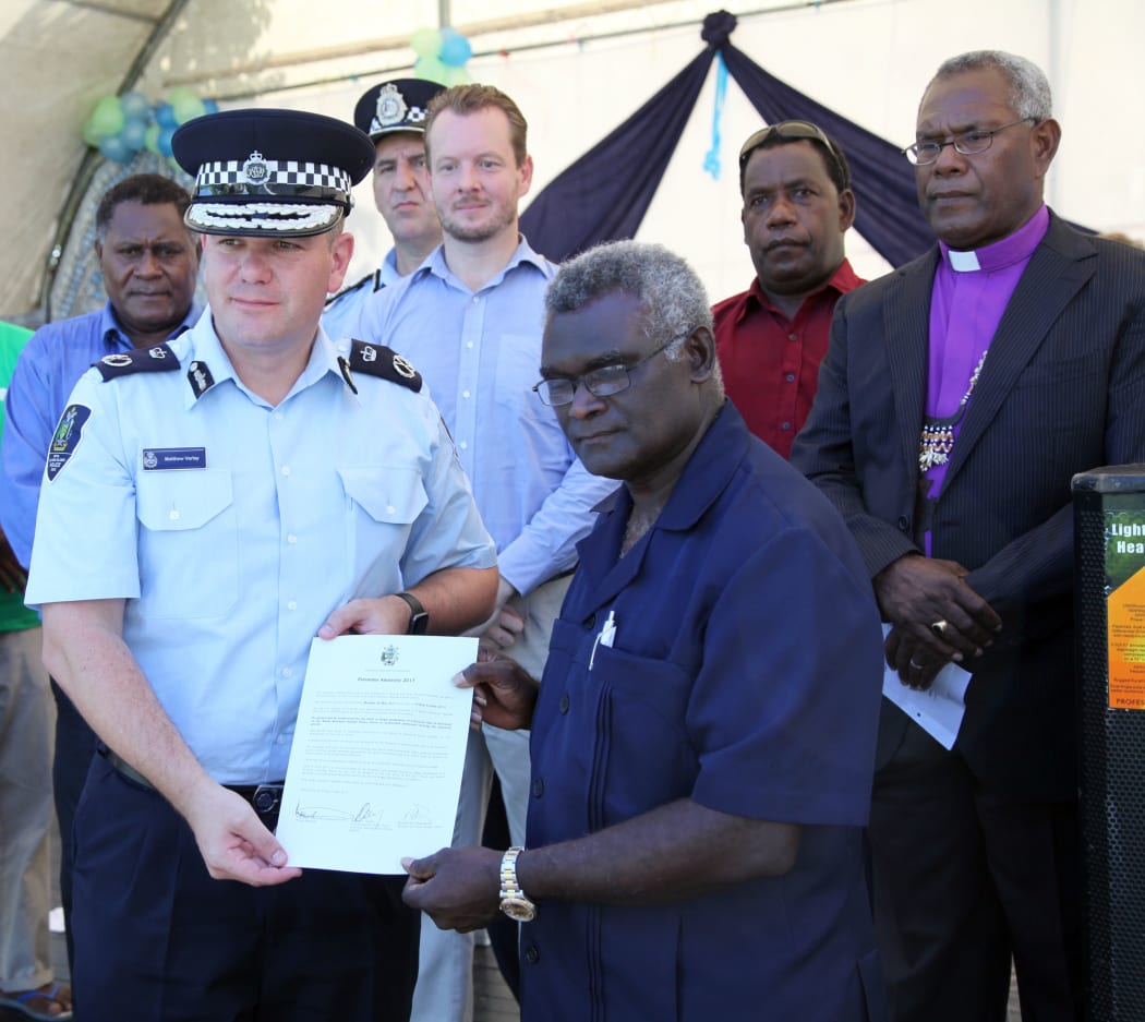 Solomon Islands prime minister Manasseh Sogavare (front R) and police commissioner Matthew Varley shortly after signing the two week amnesty document.