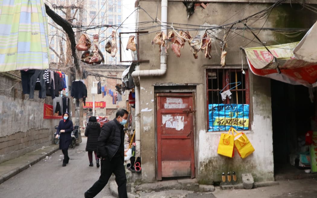 People wearing masks are seen near the Huanan Seafood Wholesale Market where Coronavirus COVID-19 clusters occurred in Wuhan, Hubei province on Jan. 15, 2021. ( The Yomiuri Shimbun ) (Photo by YOMIURI SHIMBUN / Yomiuri / The Yomiuri Shimbun via AFP)