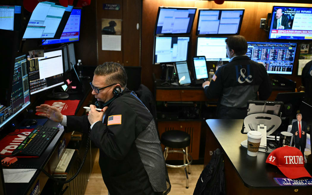 Traders and financial professionals work on the floor of the New York Stock Exchange (NYSE) at the opening bell on January 27, 2025 in New York City. European and Asian stock markets mostly slid Monday and Wall Street was forecast to open sharply lower on talk that a cheaper Chinese generative AI programme can outperform big-name rivals, notably in the United States. (Photo by ANGELA WEISS / AFP)