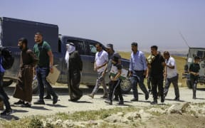 Palestinians leave the scene after performing Friday prayers near the lands that Israeli settlers are threatening to confiscate, after the armed Israeli forces prevented them from reaching their lands, in the Dhahiriya area, south of Hebron, on May 9, 2025. (Photo by Mosab Shawer / Middle East Images / Middle East Images via AFP)