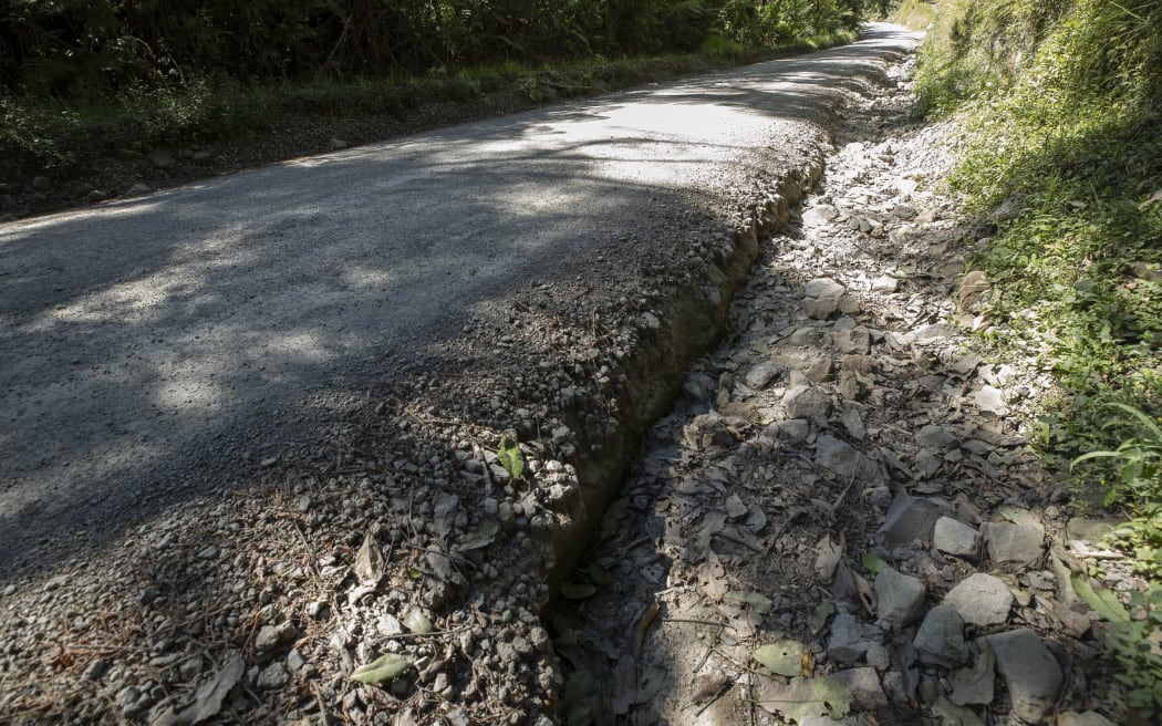Water runoff has created channels that have narrowed the road.