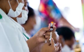 This handout picture released from UNICEF Samoa shows nurse April Wilson (L) and team leader Luisa Popo preparing vaccinations during a nationwide campaign against measles in the Samoan town of Le'auva'a.