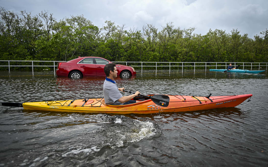 A resident uses a kayak to travel on a flooded road in Tampa, Florida, on 30 August, 2023, after Hurricane Idalia made landfall.