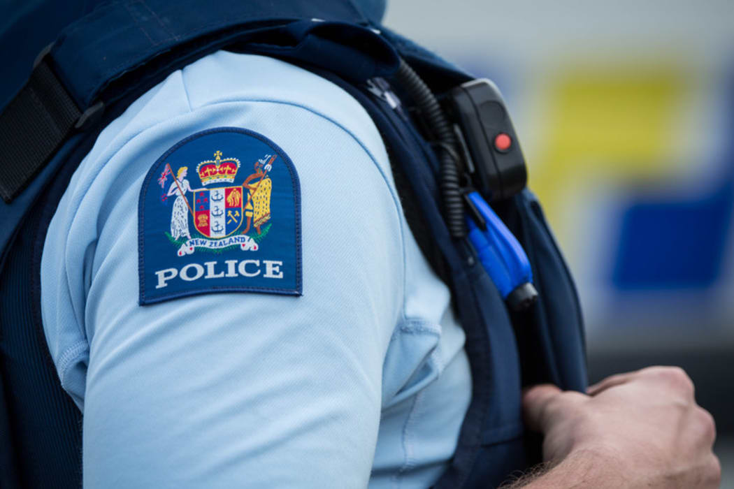 Close up of a police officer at an incident on a residential street. 6 July 2016.