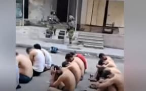 A screenshot of a video circulating on social media of detained Palestinians, stripped and guarded by Israeli forces.