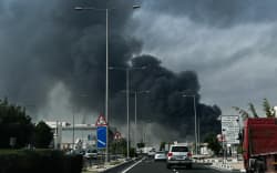 Motorists drive past a plume of smoke rising from a reported Iranian strike in the industrial district of Doha on March 1, 2026. US President Donald Trump said on February 28 that Iran’s supreme leader Ayatollah Ali Khamenei was dead, after Israel and the United States launched an attack of unprecedented scale aimed at bringing down the Islamic republic. (Photo by Mahmud HAMS / AFP)