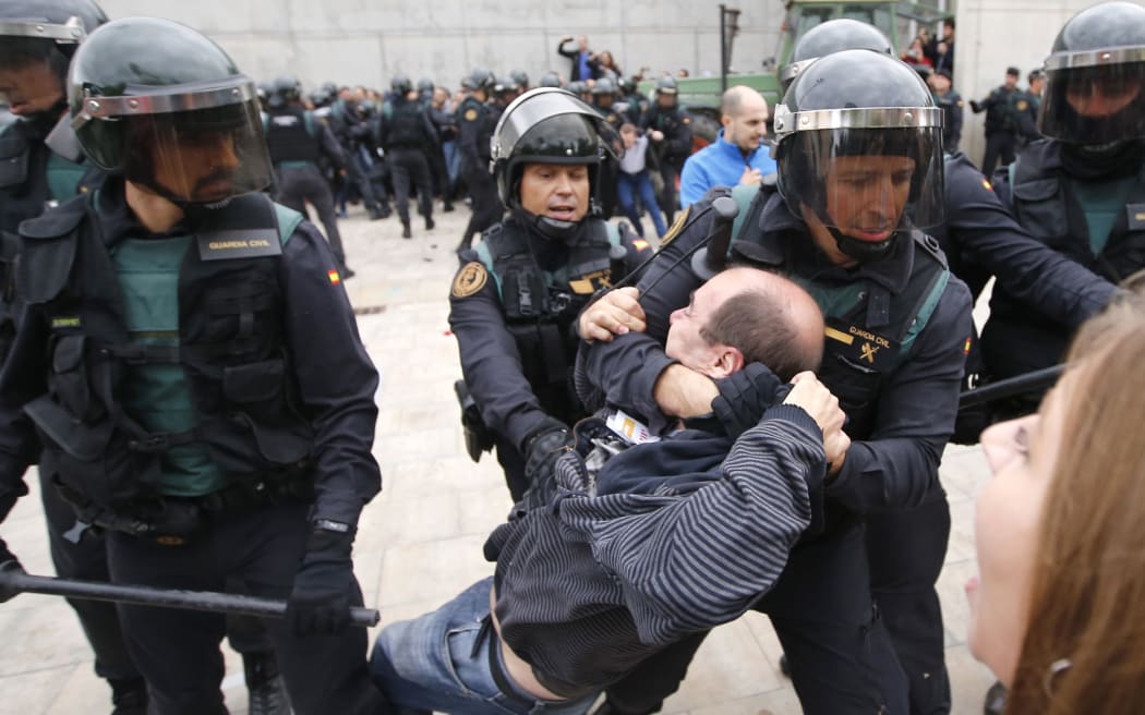 Spanish Guardia Civil guards drag a man outside a polling station in Sant Julia de Ramis, where Catalan president was supposed to vote, on October 1, 2017,