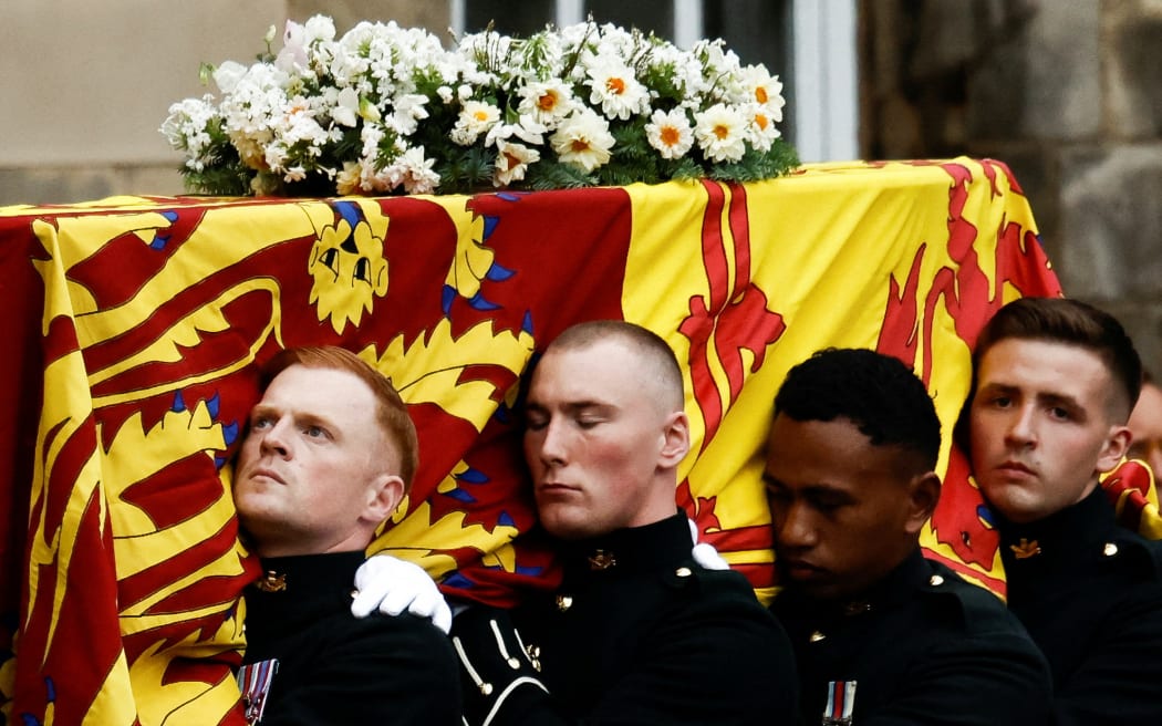 Pallbearers carry the coffin of late Britain's Queen Elizabeth II covered with the Royal Standard of Scotland, at the Palace of Holyroodhouse, in Edinburgh on 11 September 2022.