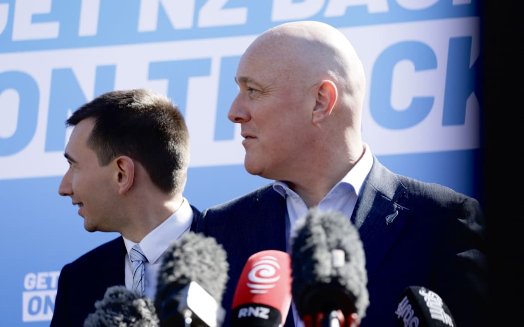 National Party leader Christopher Luxon and MP Simeon Brown react to heckler during press conference in Auckland on 28 August, 2023.