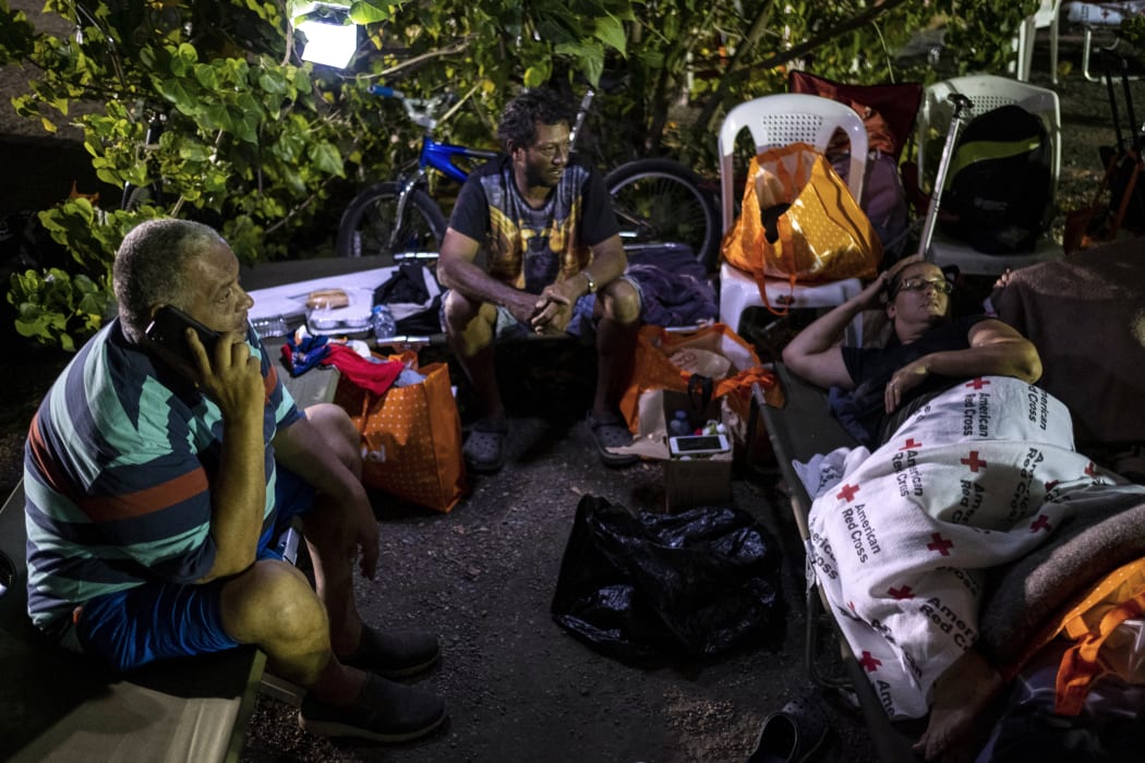 People remain outdoors under tents and using portable lights for fear of possible aftershocks after an earthquake hit the island in Guanica, Puerto Rico on January 8, 2020