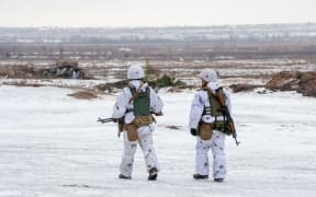 Ukrainian soldiers walk in a field during  live-fire exercises in Chuguev, Kharkiv region on February 10, 2022. (Photo by Sergey BOBOK / AFP)