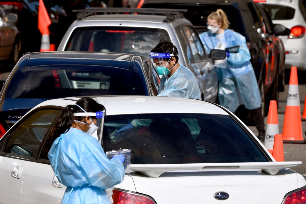 Medical personnel take details at a drive-through Covid-19 testing station in Melbourne on August 19, 2021, as Australia battles an outbreak of the Delta variant of coronavirus.