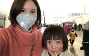 Lily Gao and her two-year-old daughter Elysse at the Wuhan airport, waiting to be evacuated by a government-chartered flight.