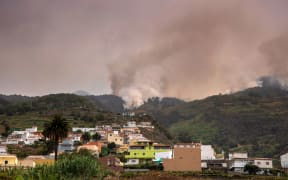 A wildfire rages out of control through forested slopes in La Matanza on the Canary island of Tenerife on August 19, 2023. More than 26,000 people may have been forced to flee a vast wildfire raging out of control in the Spanish holiday island of Tenerife, the emergency services said today. The huge blaze, which broke out late Tuesday in a mountainous northeastern area of the island, is the "most complex fire" to hit Spain's Atlantic Canary Islands in more than 40 years, the authorities say. (Photo by DESIREE MARTIN / AFP)