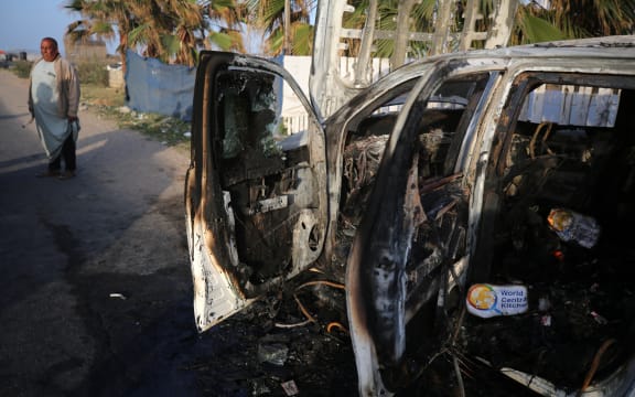 Palestinians are standing next to a vehicle in Deir Al-Balah, in the central Gaza Strip, on April 2, 2024, where employees from the World Central Kitchen (WCK), including foreigners, were killed in an Israeli airstrike, according to the NGO. The Israeli military is stating that it is conducting a thorough review at the highest levels to understand the circumstances of this ''tragic'' incident, amid the ongoing conflict between Israel and Hamas. (Photo by Majdi Fathi/NurPhoto) (Photo by MAJDI FATHI / NurPhoto / NurPhoto via AFP)