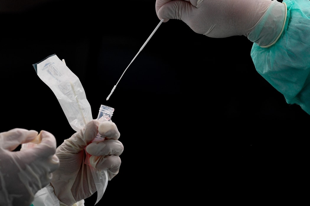 A health worker puts a swab into a tube after collecting a sample for Covid-19 coronavirus testing in Gombak on the outskirts of Kuala Lumpur on April 22, 2020.
