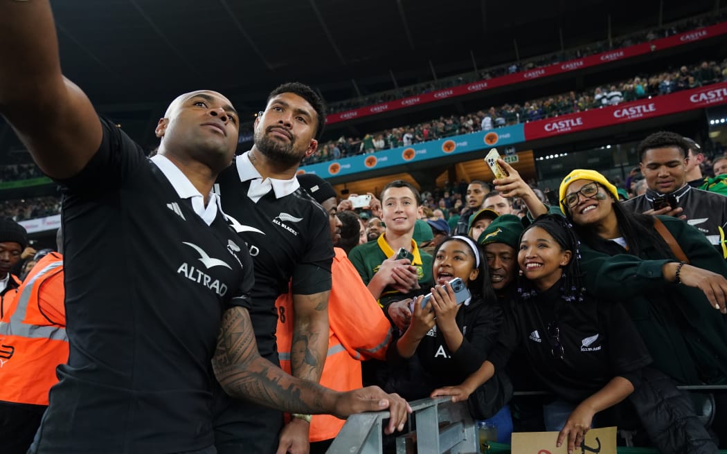 Mark Tele'a, left and Ardie Savea of the All Blacks with fans.