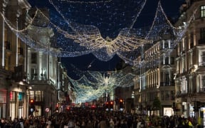 Shoppers walk on Regent Street decorated with festive lights as new coronavirus restrictions, announced today by British Prime Minister Boris Johnson, are due to take effect from midnight on Sunday, on 19 December, 2020 in London, England.