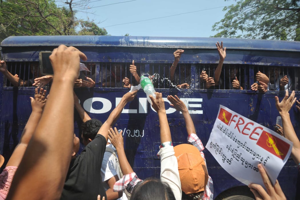 Myanmar student protesters and activists gesture from a departing police truck following a court hearing in Letpadan on April 7, 2015.