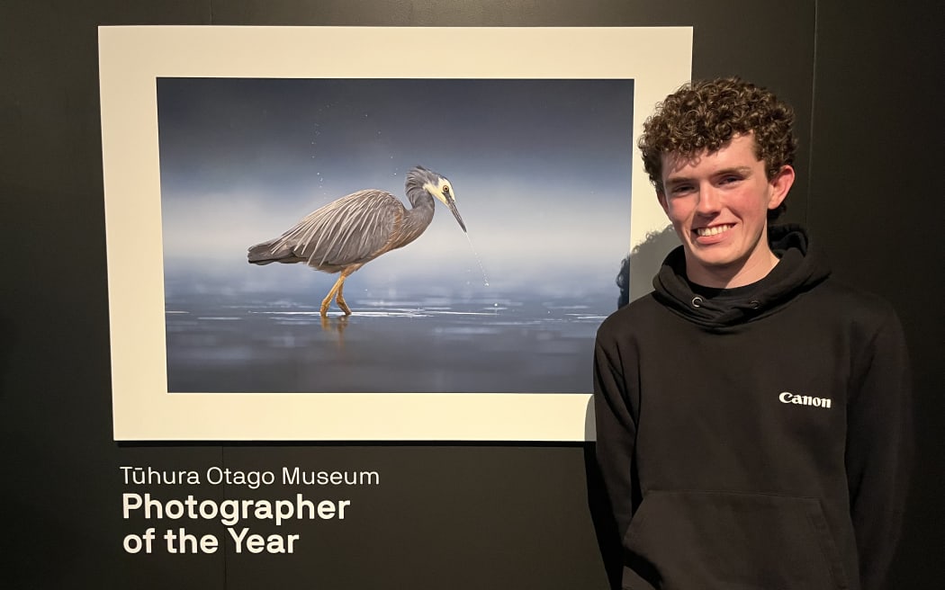 Sam McGee standing by his winning photo - Water Wings - of a white-faced heron.