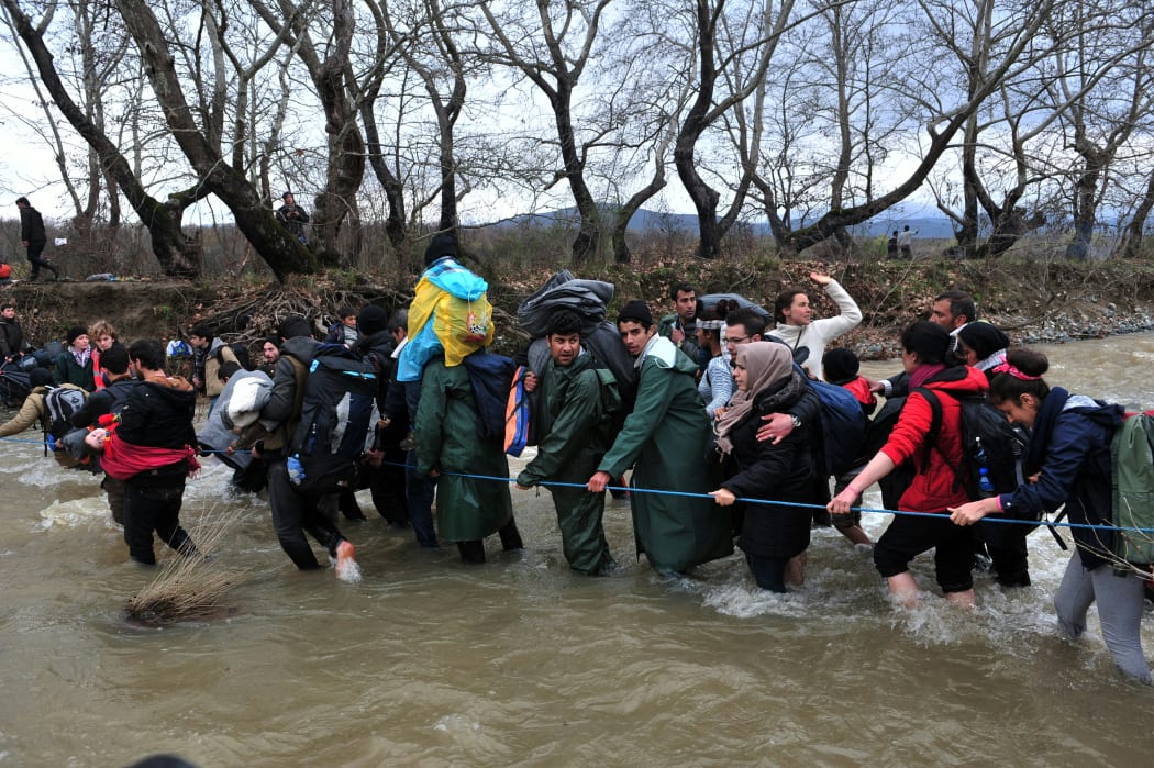 Refugees formed a human chain across the river to help people cross into Macedonia.